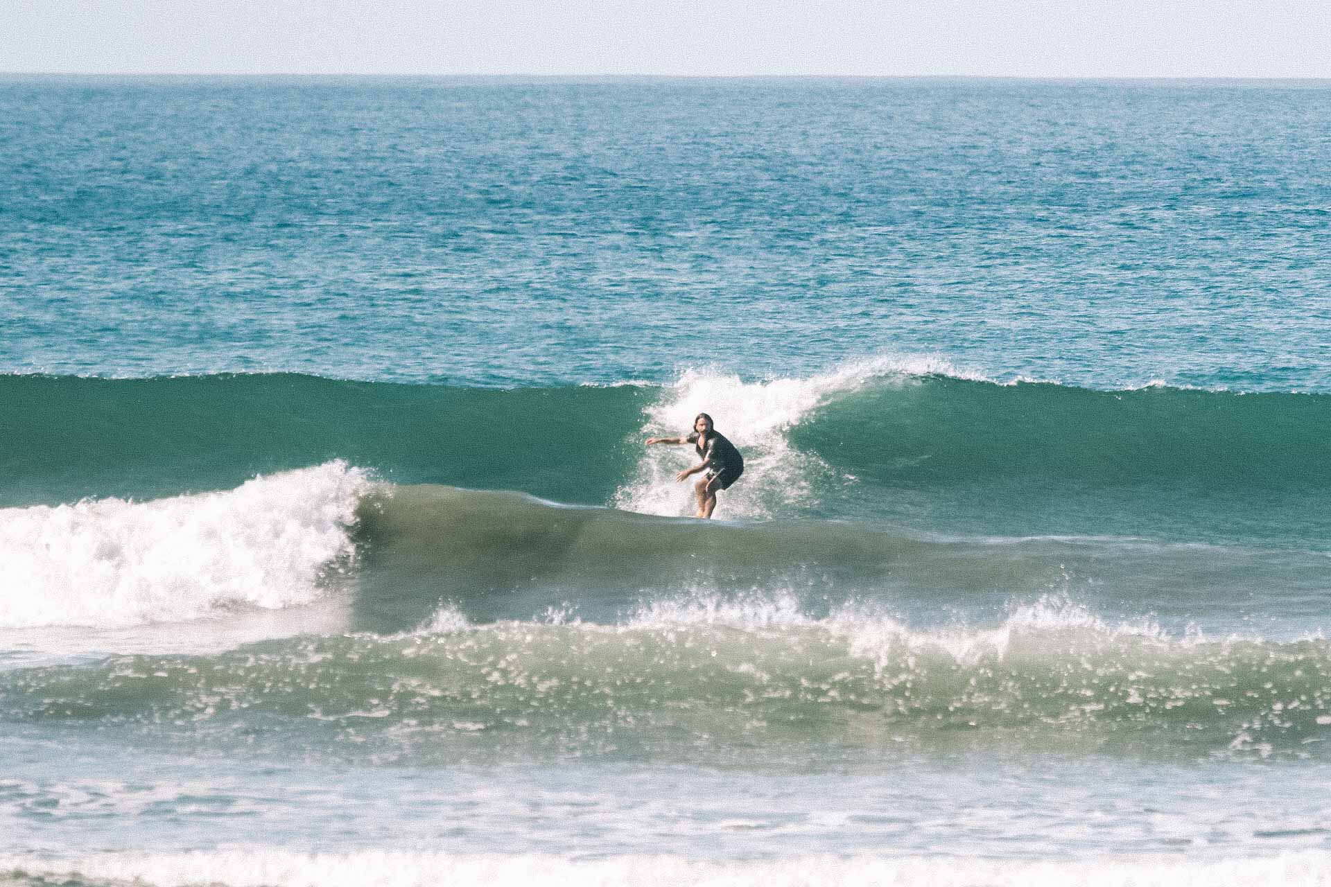 Surfer backside turning on a wave 